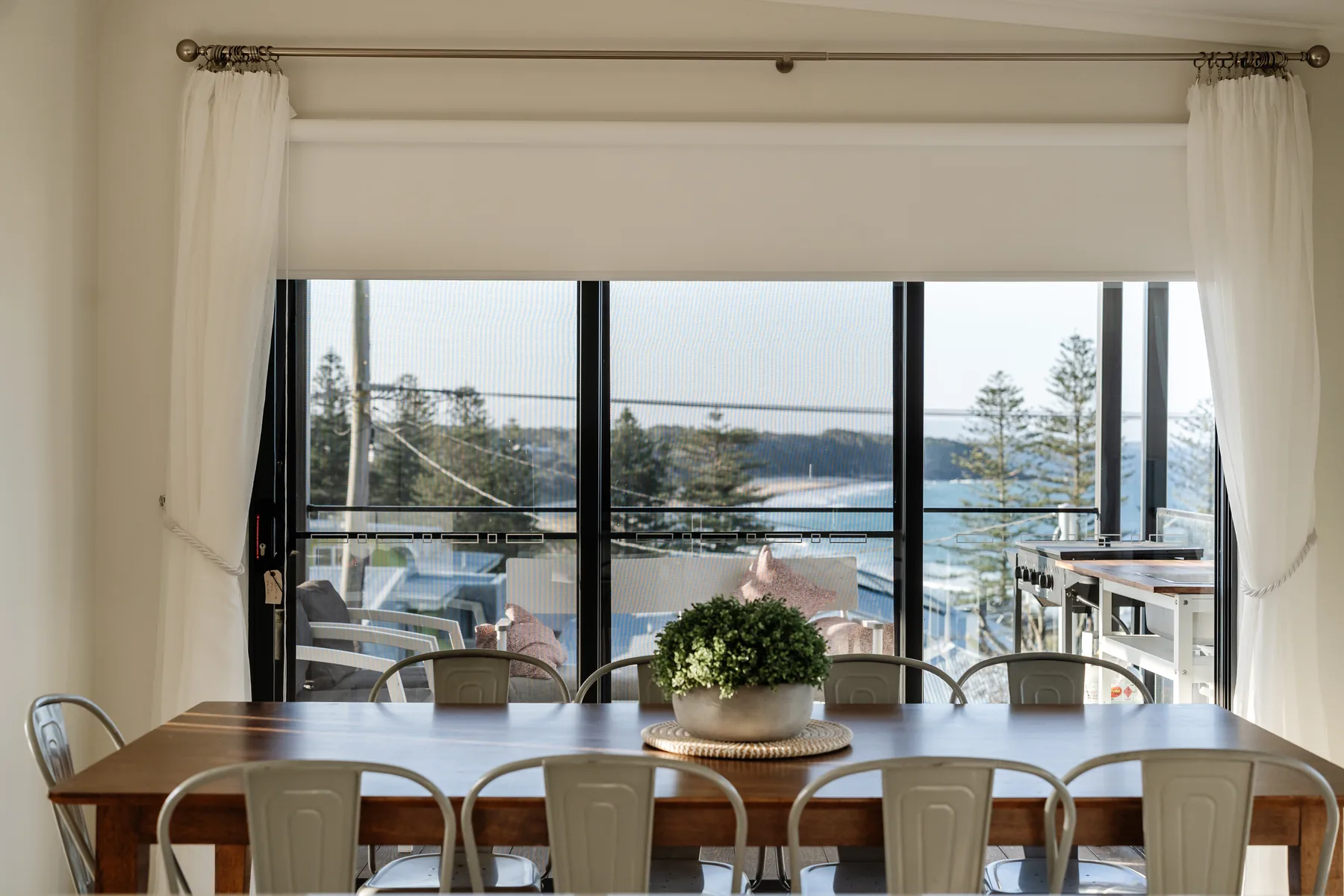 Dining table with ocean views through full-height glass