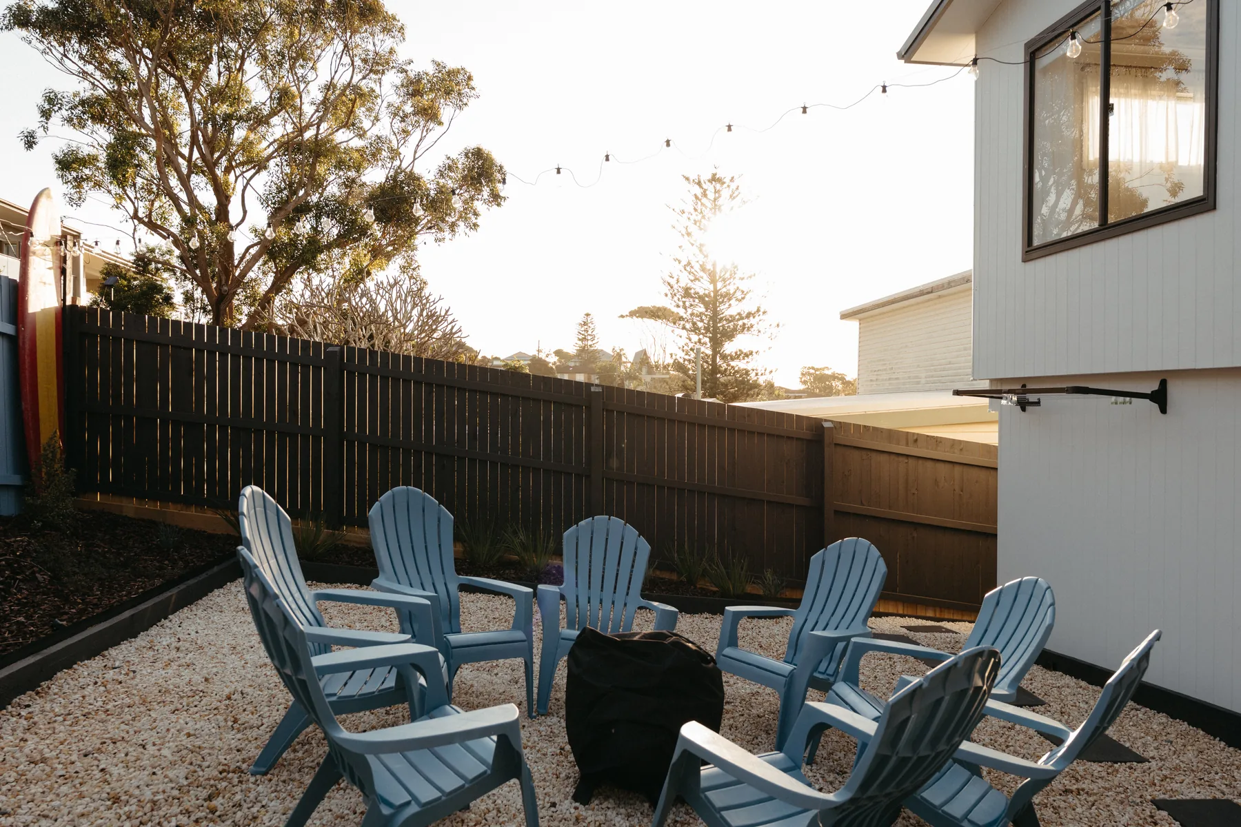 Backyard fire pit with Adirondack chairs at dusk
